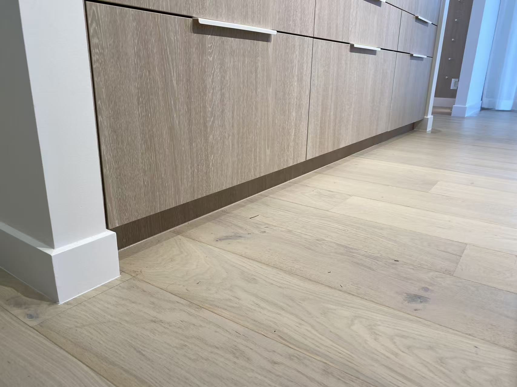 Flooring meeting the base of fitted cabinetry