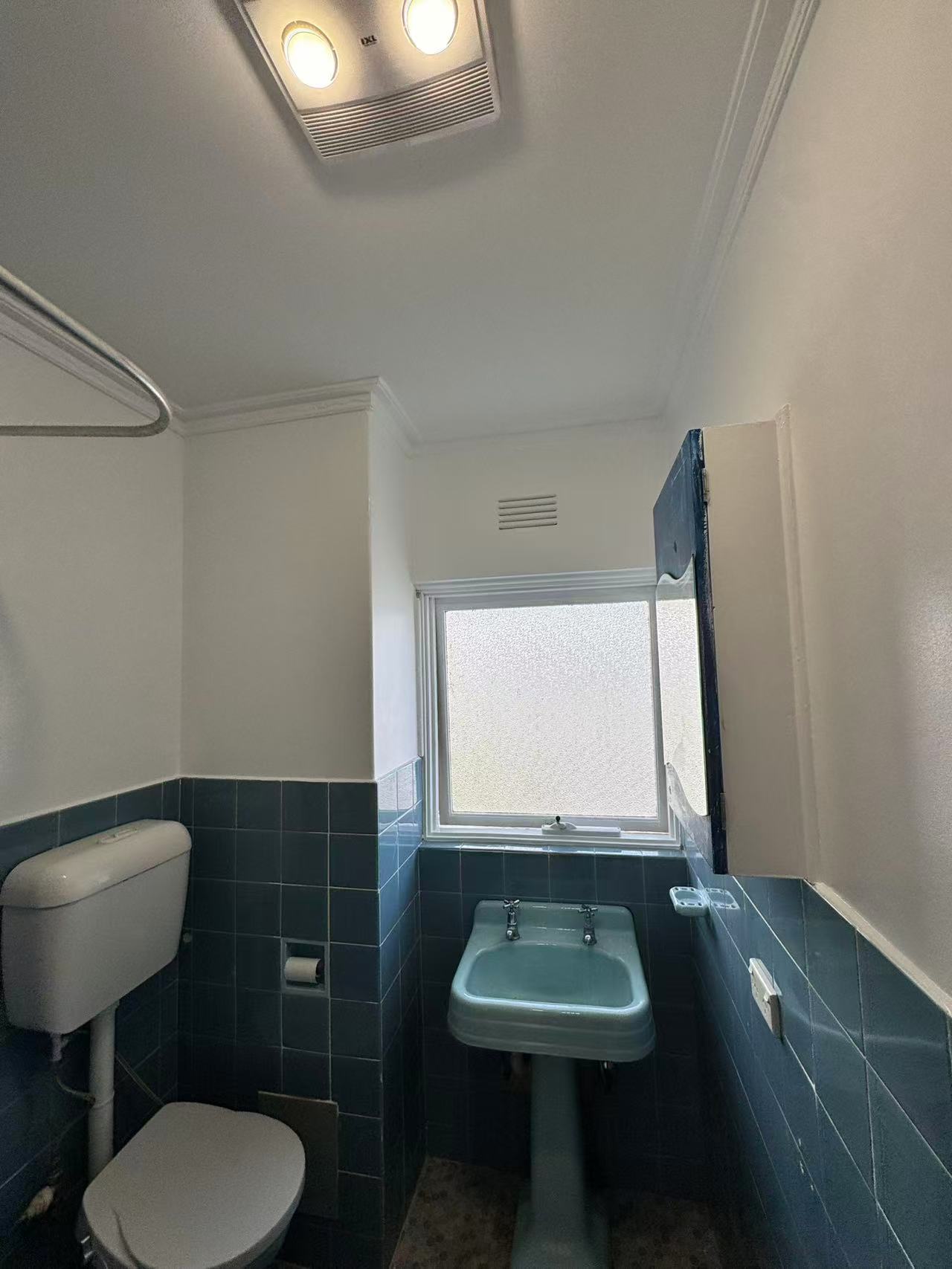 Blue-tiled bathroom bath, shower fitting and toilet