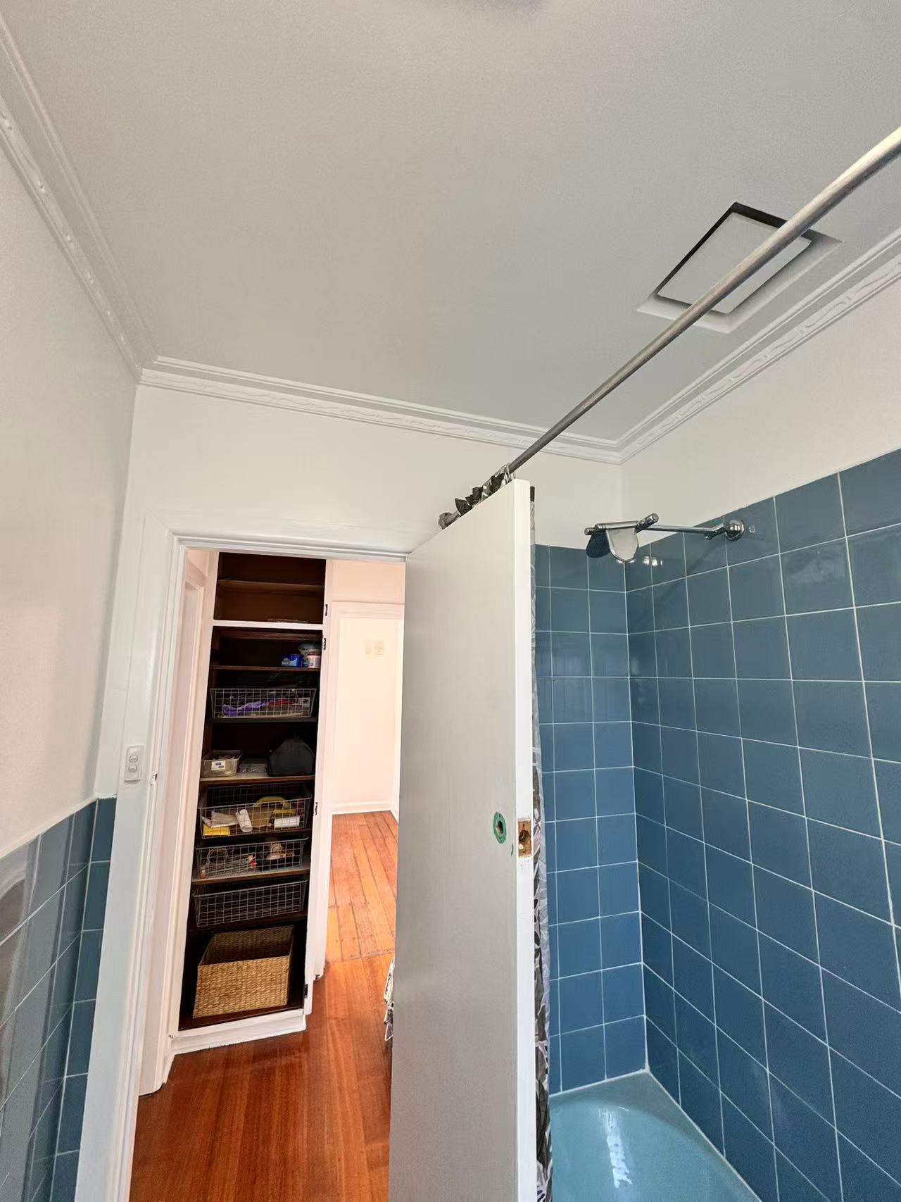 Blue-tiled bathroom shower, doorway and ceiling