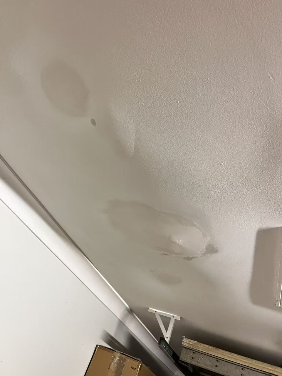 Water marks and patching on a residential utility-room ceiling